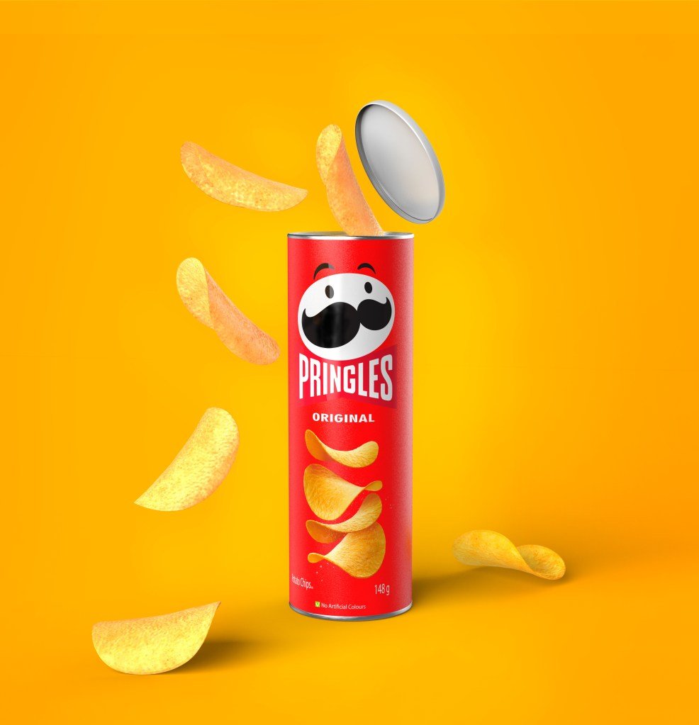 Open package of Pringles crisps with spilled chips, on a yellow background